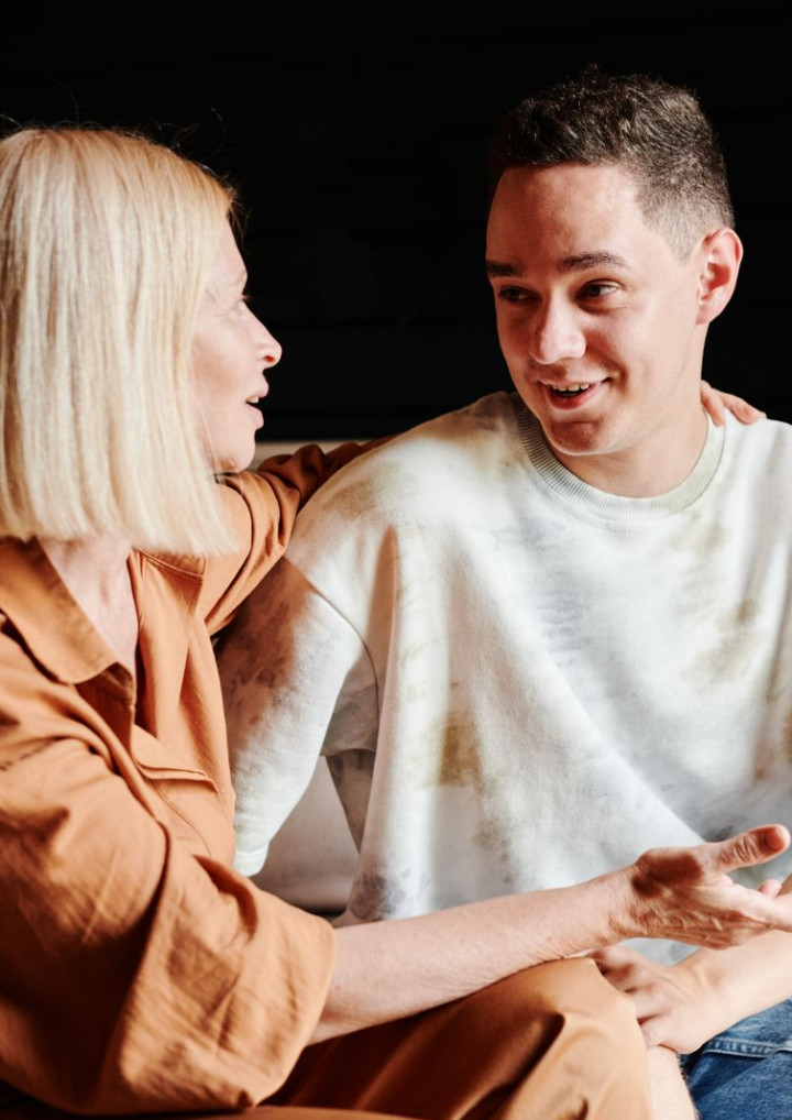 Eine Mutter und ihr Sohn sitzen nebeneinander und sprechen miteinander
