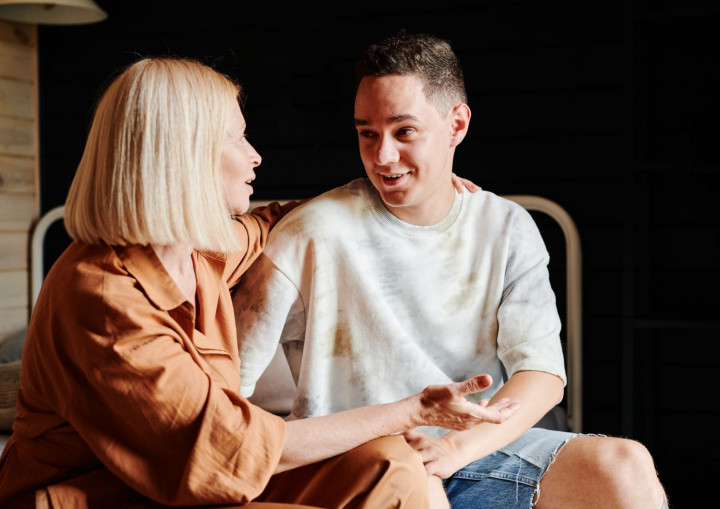 Eine Mutter und ihr Sohn sitzen nebeneinander und sprechen miteinander