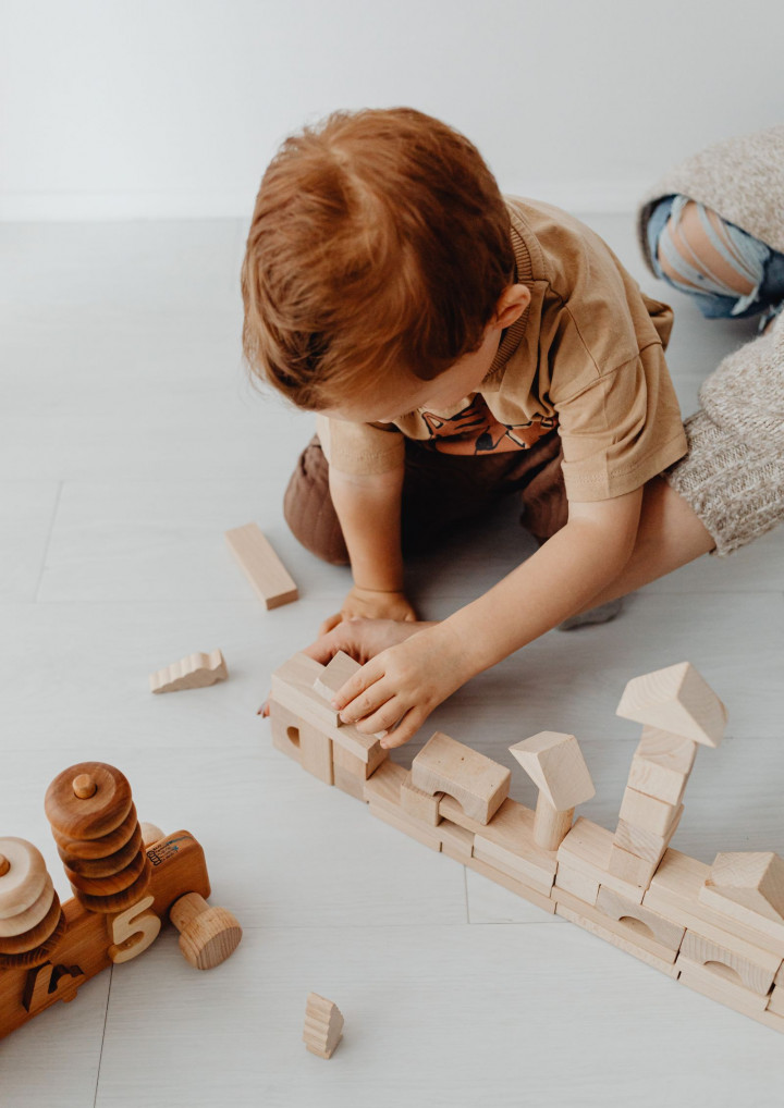 Ein Kind spielt mit Holz-Bauklötzen
