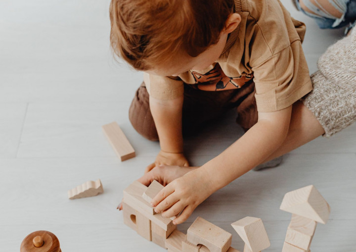 Ein Kind spielt mit Holz-Bauklötzen